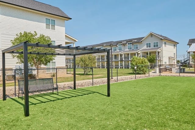 Pergola with bench on lawn exterior at Wildwood Lubbock in Lubbock Student Accommodation