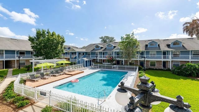Apartment buildings with pool and lounge chairs exterior at Apartments In Gainesville FL in Gainesville Student Accommodation