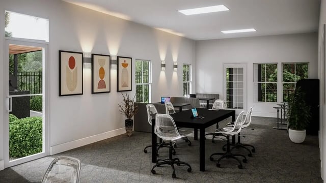 Work area with tables chairs and laptops common area at The Asher in Tallahassee Student Accommodation