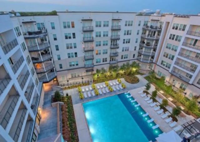 Apartment building with pool and lounge chairs exterior at 101 Center in Arlington Student Accommodation