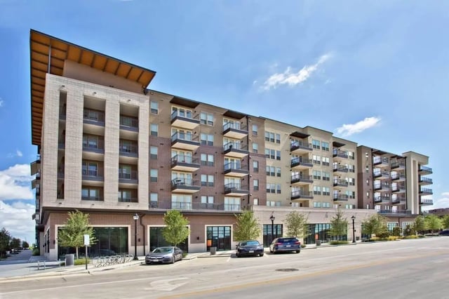 Modern apartment building with balconies and cars exterior at 101 Center in Arlington Student Accommodation