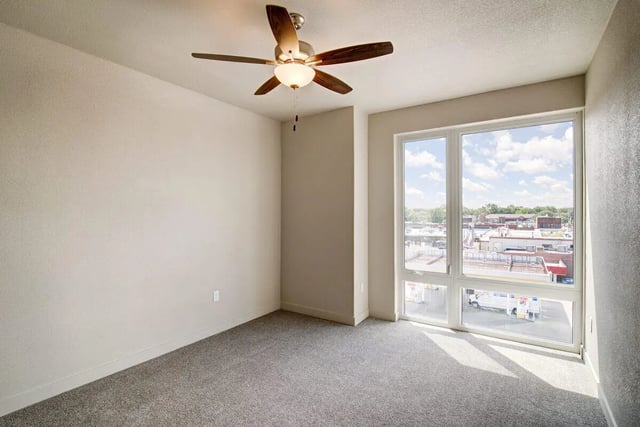 Empty room with ceiling fan and large window bedroom at 12b Lofts Apartments in Manhattan Student Accommodation