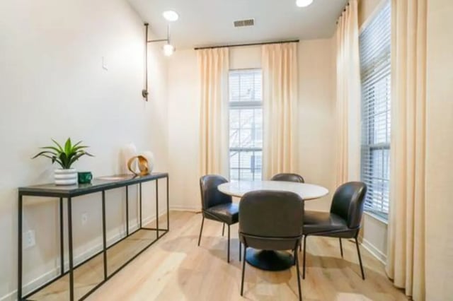 Dining table chairs console table plant living area at The Tate on Howard in Kalamazoo Student Accommodation