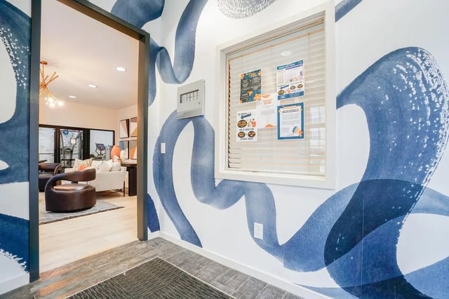 Blue wall art with bulletin board and seating area at The Tate on Howard in Kalamazoo Student Accommodation