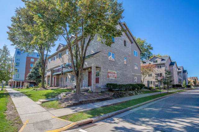Row of brick townhouses with rental office exterior at College Park Apartments in Ithaca Student Accommodation