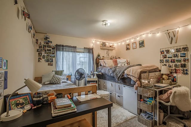 Two beds desk fan string lights bedroom interior at College Park Apartments in Ithaca Student Accommodation