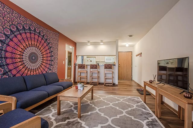 Blue sofa coffee table and kitchen area living room at College Park Apartments in Ithaca Student Accommodation