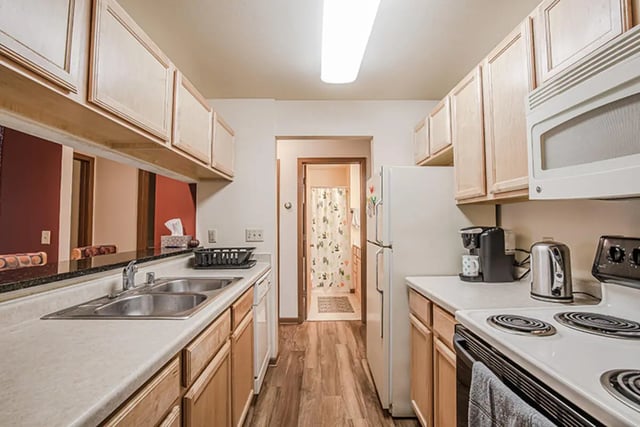 Kitchen counters appliances cabinets and a doorway to bathroom kitchen at College Park Apartments in Ithaca Student Accommodation