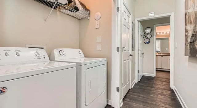 Washer dryer shelves white doors hallway bathroom at The Flats at Atlantic Station in Atlanta Student Accommodation