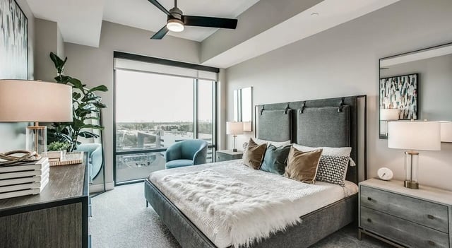 Gray upholstered bed with plush throw and pillows Bedroom at The Flats at Atlantic Station in Atlanta Student Accommodation
