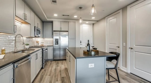 Modern kitchen with island stainless steel appliances and white cabinetry kitchen at The Flats at Atlantic Station in Atlanta Student Accommodation