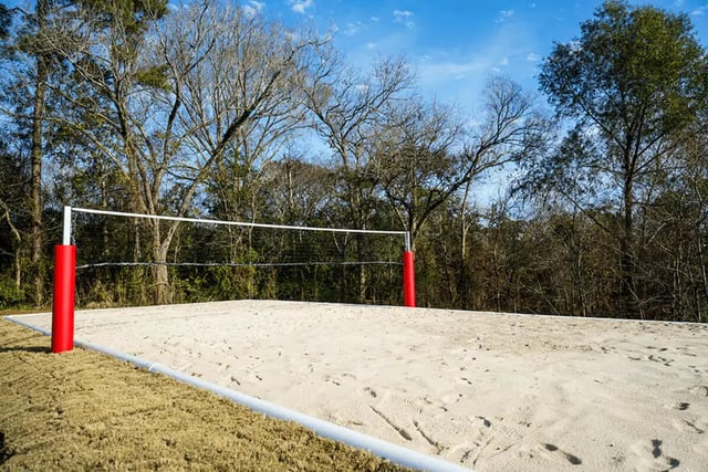 Volleyball court with net and red poles playing area at The Pointe at Pinhook in Lafayette Student Accommodation