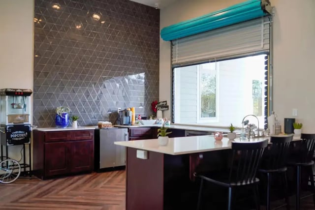 Popcorn machine cabinets sink and bar stools kitchen at The Pointe at Pinhook in Lafayette Student Accommodation