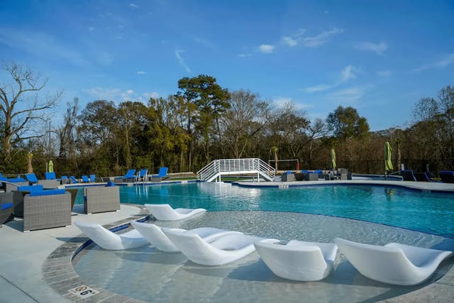 Poolside lounging furniture white bridge swimming pool exterior at The Pointe at Pinhook in Lafayette Student Accommodation