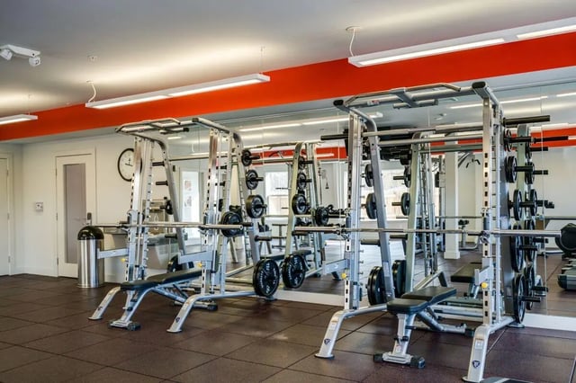 Weight racks benches and barbells gym area at The Rocks in East Lansing Student Accommodation