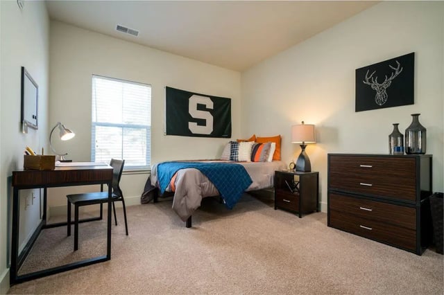 Desk bed dresser and lamp bedroom at The Rocks in East Lansing Student Accommodation