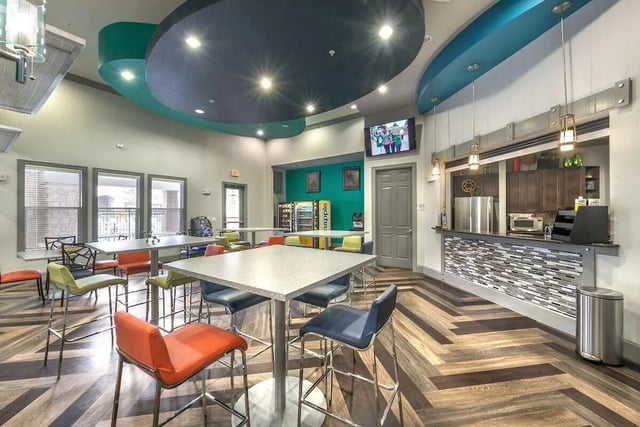Bar area with tables and colorful chairs communal space at Forum at Denton Station in Denton Student Accommodation