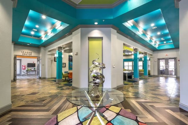 Modern lobby with abstract sculpture and colorful rug communal area at Forum at Denton Station in Denton Student Accommodation