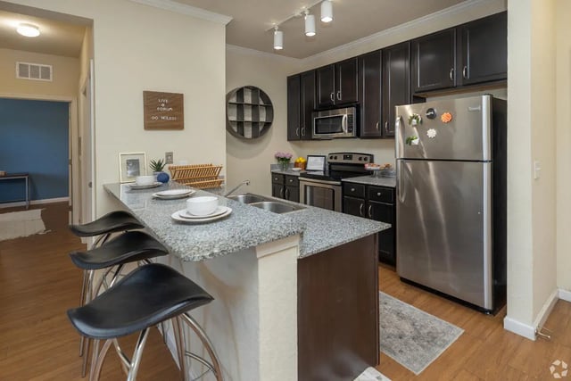 Kitchen island with stools and appliances kitchen at Forum at Tallahassee in Tallahassee Student Accommodation
