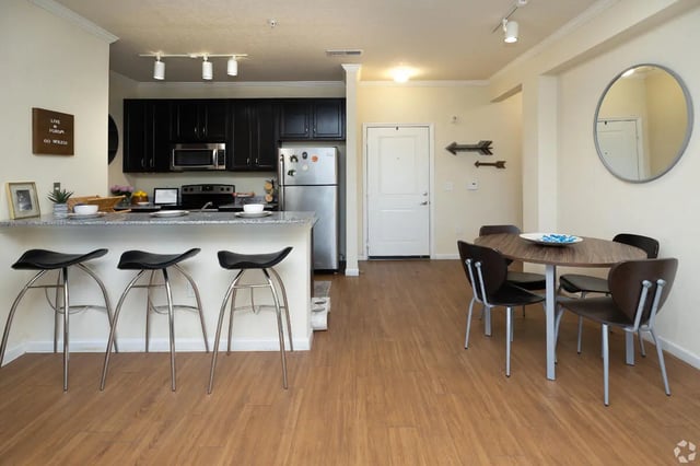 Kitchen counter with stools dining table chairs Living room at Forum at Tallahassee in Tallahassee Student Accommodation