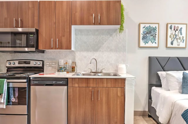Kitchenette with microwave stove sink and bed at The Icon & Lofts at the Icon in Houston Student Accommodation