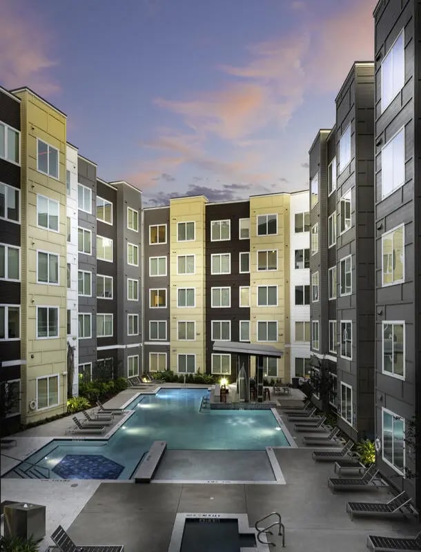 Apartment buildings surrounding a pool lounge chairs exterior at The Icon & Lofts at the Icon in Houston Student Accommodation