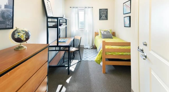 Desk bed globe shelving and rug bedroom at 100 Midtown in Atlanta Student Accommodation