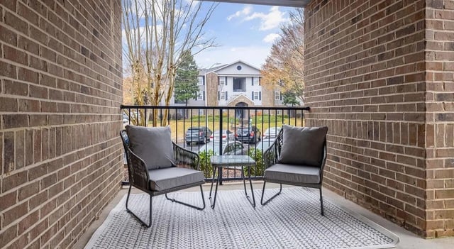 Two chairs and table on balcony exterior at 403 West in Raleigh Student Accommodation