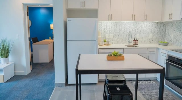 Table stools white refrigerator kitchen island kitchen at Cheatham Street Flats in San Marcos Student Accommodation