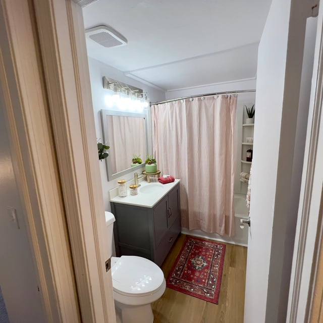 Toilet vanity mirror striped shower curtain bathroom at The Den Cedar Ridge in Willington Student Accommodation