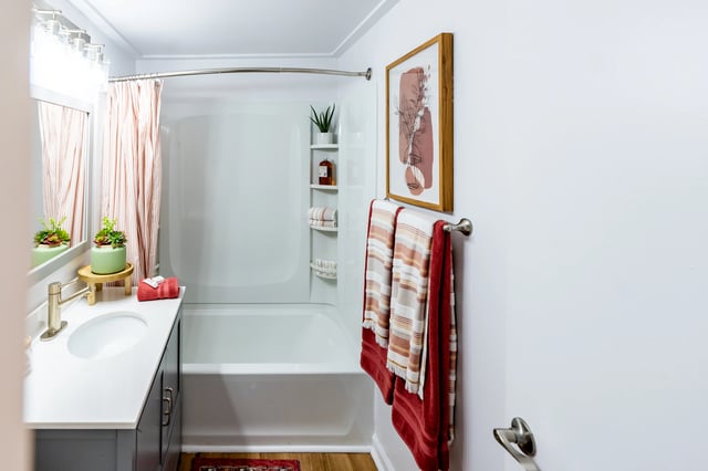 Sink bathtub towels art and plant bathroom at The Den Cedar Ridge in Willington Student Accommodation