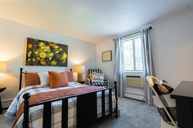 Bed with patterned bedding and artwork Bedroom at The Den Cedar Ridge in Willington Student Accommodation