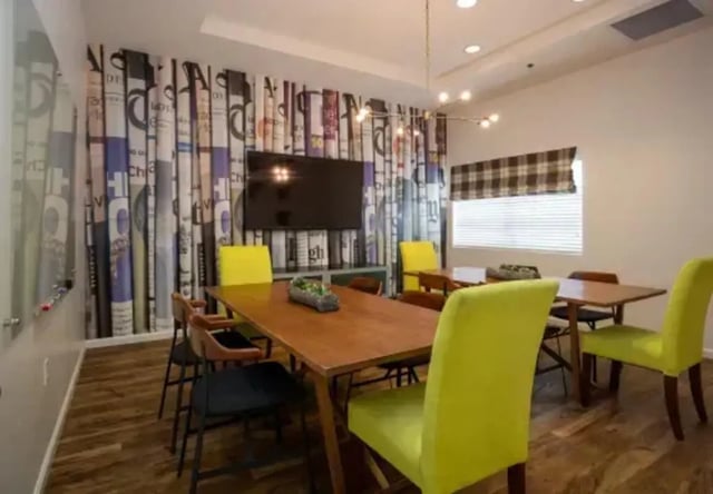 Wooden tables yellow chairs and TV communal area at The Junction At Iron Horse Student Housing in Tucson Student Accommodation