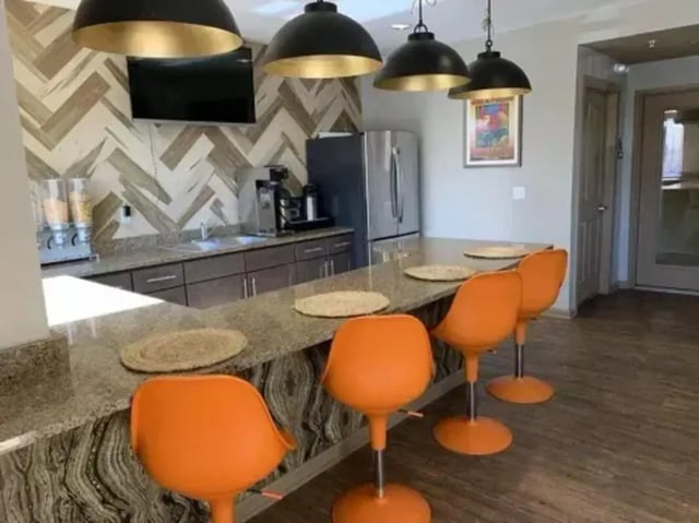 Orange bar stools at a counter kitchen area at The Junction At Iron Horse Student Housing in Tucson Student Accommodation