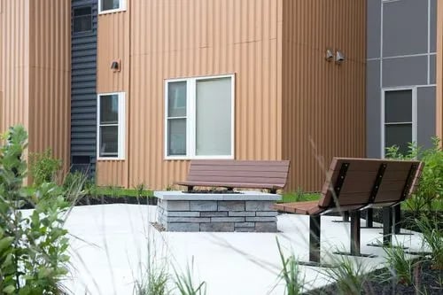 Benches by stone fire pit exterior at Campus Walk Apartments in Buffalo Student Accommodation