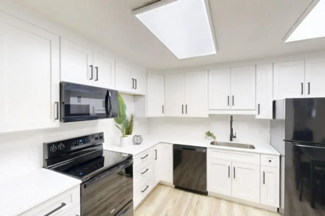 White cabinets black appliances sink dishwasher kitchen at Bountiful Court Apartments in Provo Student Accommodation