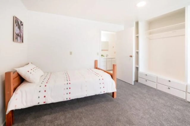 Bed with white comforter built-in closet bedroom at Bountiful Court Apartments in Provo Student Accommodation