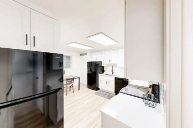 Refrigerator cabinets sink oven table and chairs kitchen at Bountiful Court Apartments in Provo Student Accommodation