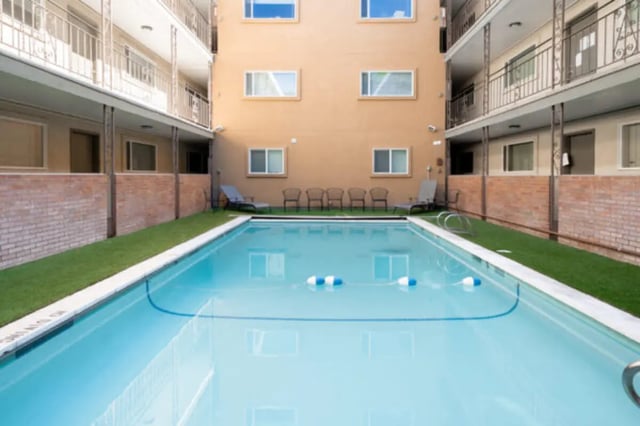 Apartment buildings surrounding a swimming pool and lounge chairs exterior at Bountiful Court Apartments in Provo Student Accommodation