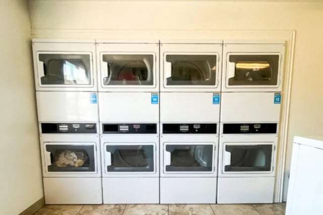 Eight stacked white washers and dryers common area laundry room at Bountiful Court Apartments in Provo Student Accommodation
