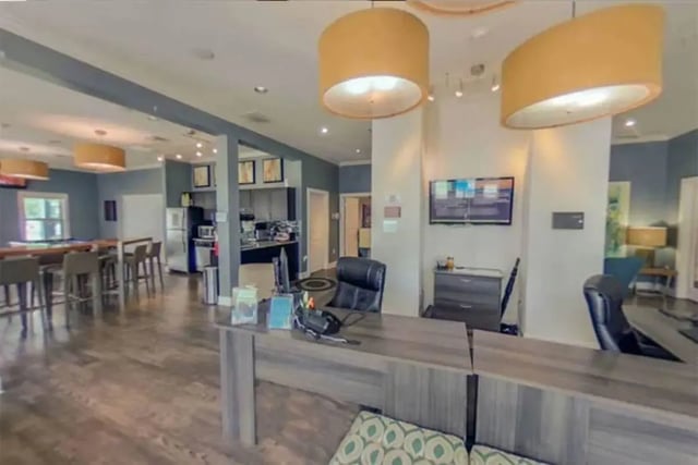 Desk chairs televisions pool table and kitchen common area at The Edge at Conway in Conway Student Accommodation