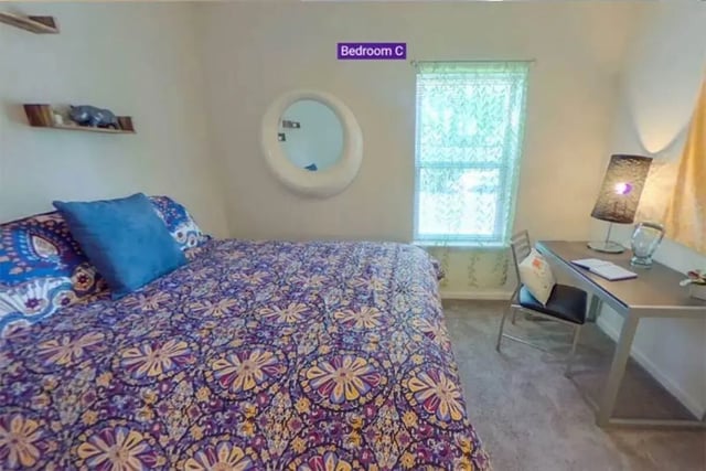 Bed with patterned quilt and desk with lamp bedroom at The Edge at Conway in Conway Student Accommodation