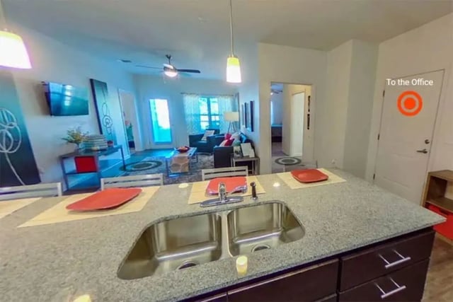 Kitchen island with sink and living room living room at The Edge at Conway in Conway Student Accommodation