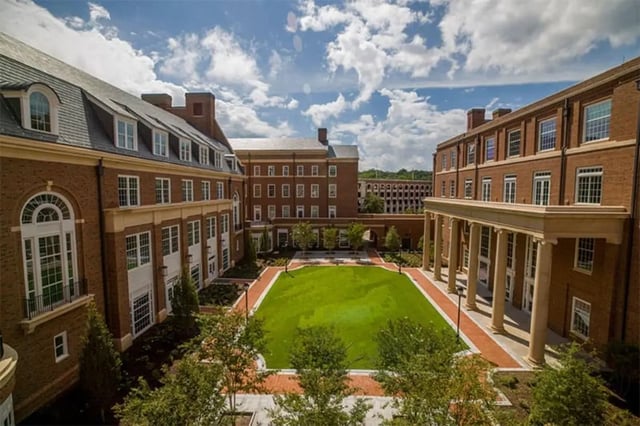 Brick buildings surround green courtyard exterior at Arches On The Lake Student Living in Athens Student Accommodation