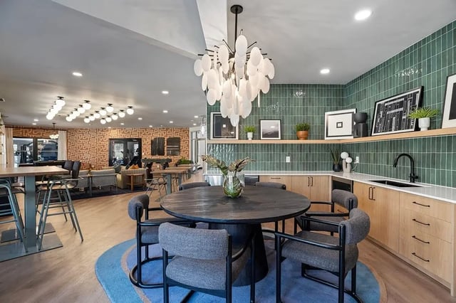 Round table chairs kitchen counter modern chandelier communal area at Arches On The Lake Student Living in Athens Student Accommodation