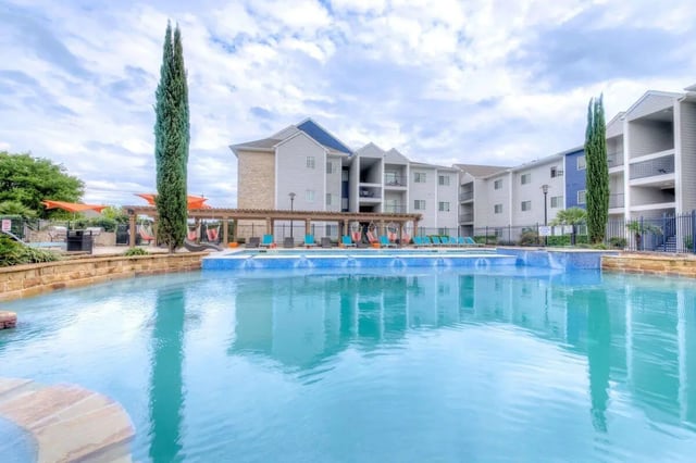 Apartment complex with pool and lounge chairs exterior at The Reserve San Antonio in San Antonio Student Accommodation