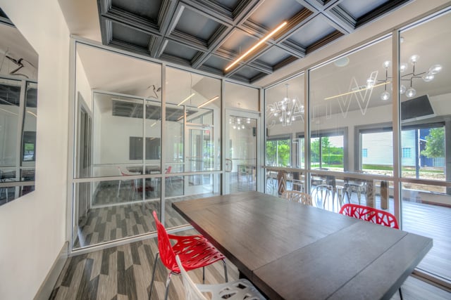 Wooden table red chairs glass walls communal area at The Reserve San Antonio in San Antonio Student Accommodation