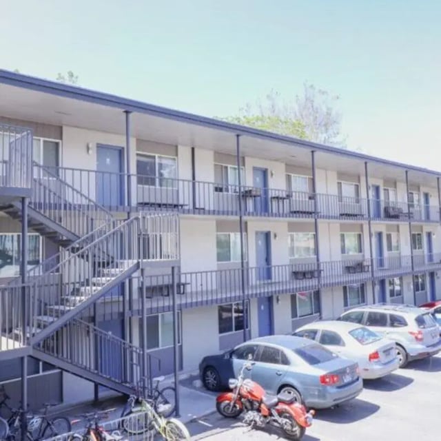 Apartment building exterior with parked cars and motorcycles exterior at Campus Way in Provo Student Accommodation