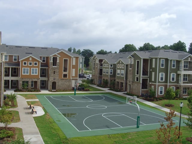 Apartment buildings surrounding basketball court exterior at The Letterman Greensboro in Greensboro Student Accommodation