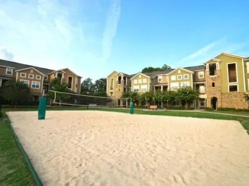 Volleyball court in front of apartment buildings exterior at The Letterman Greensboro in Greensboro Student Accommodation